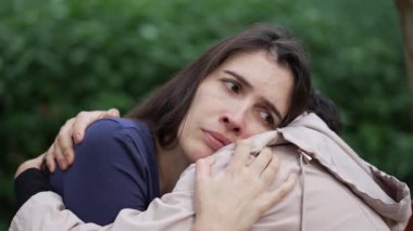 Üzgün kadın gözlerini açıyor. Bir arkadaşı destekliyor ve ona yardım ediyor.