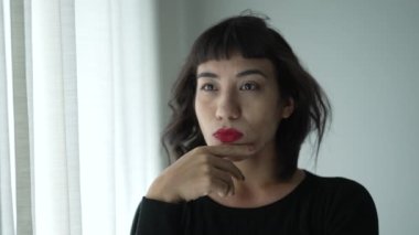 Düşünceli, Latin bir kadın pencerenin kenarında durup düşünüyor. Düşünceli bir Yerli Yerli kökenli.