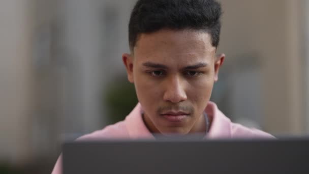 Крупный План Бразильского Молодого Человека Смотрящего Экран Ноутбука Работающего Удаленно — стоковое видео