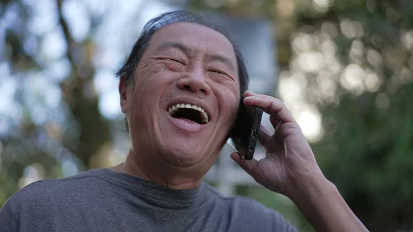 Happy Senior Asian Man Speaking Phone While Walking City Street — Zdjęcie stockowe