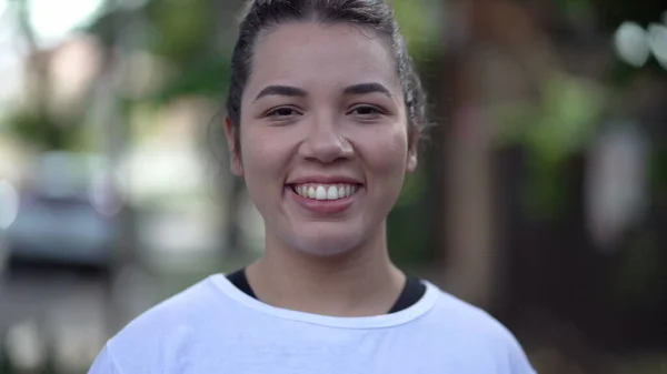 一人のブラジル人のヒスパニック系の若い女性がカメラに向かって歩いている 南アメリカの女の子で20代の笑顔で街の歩道 — ストック写真