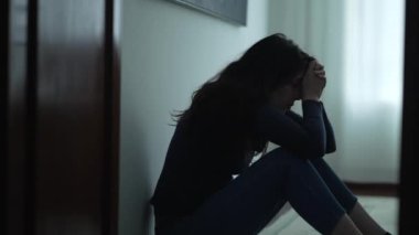 Acı çeken kadın yerde oturmuş akıl hastalığıyla boğuşuyor. Evde yalnız bir insan depresyondan muzdarip.