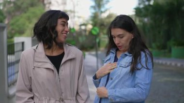 Sokakta yürürken kadın arkadaşına mavi ceketi gösteren bir kadın..