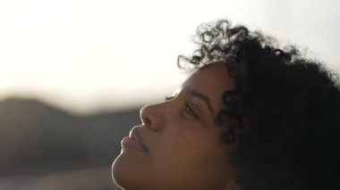Meditasyoncu Afro-Amerikan derin düşüncelere dalarak gözlerini kapatıyor. Kaygısız siyah bir kız gökyüzüne gözlerini açıyor yakın çekim yüzü