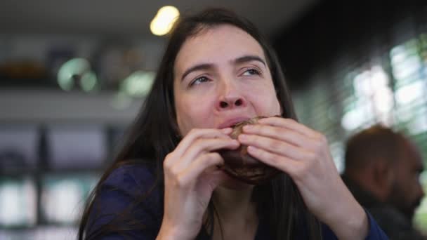 Mujer Comiendo Hamburguesa Con Queso Persona Mordiendo Pedazo Hamburguesa Restaurante — Vídeos de Stock