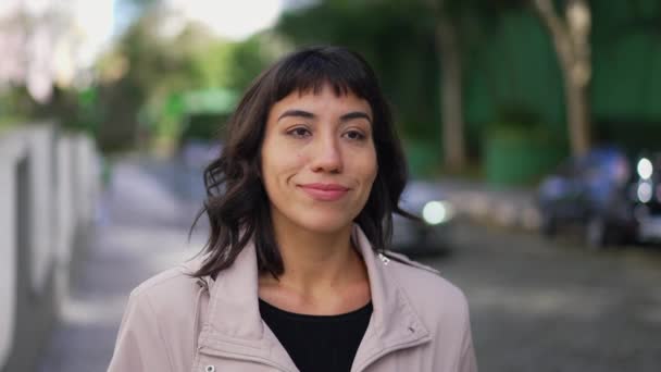 1つの幸せな若いヒスパニック系ラテン語の女性を前に笑顔歩いてください 顔を笑顔で通りを歩く人 — ストック動画