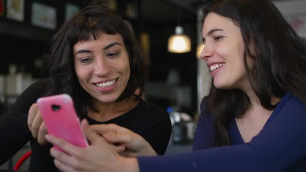 Δύο Φίλες Συζητούν Καφετέρια Εστιατόριο Ενώ Κοιτάζουν Συσκευή Smartphone Νεαρές — Αρχείο Βίντεο