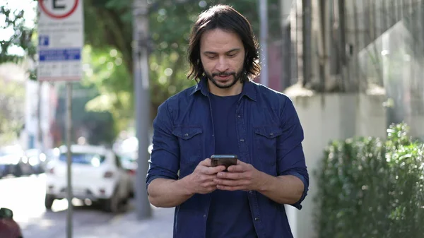 One Young Hispanic Man Looking Cellphone Device While Walking City — 스톡 사진