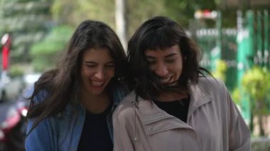 Dışarıda gülen ve gülümseyen iki bayan arkadaş. Arkadaşlık gerçek hayatta güler ve gülümser.