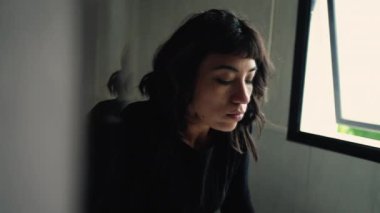 Banyo aynasında kendi yansıma camına bakan bir kadın. Düşünceli düşünceli kız aynaya bakıyor..