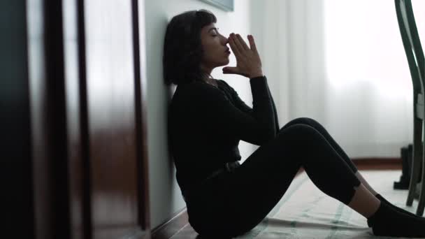 困難な時代に神の助けを求めて床に座っている若い女性 — ストック動画