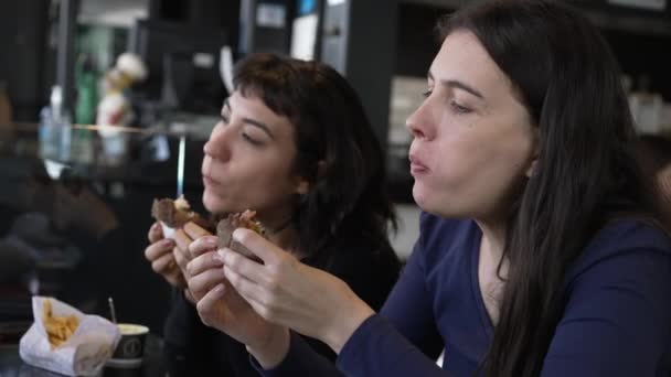 Ευτυχισμένοι Φίλοι Τρώνε Χάμπουργκερ Στο Εστιατόριο Για Μεσημεριανό Γεύμα — Αρχείο Βίντεο