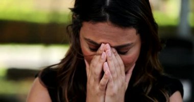 Endişeli İspanyol kadın elini göğsüne koydu. Gerginlik hissetti.