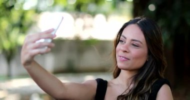 Güzel İspanyol kadın dışarıda telefonuyla selfie çekiyor..