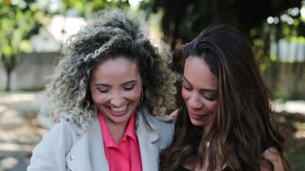 Duas Mulheres Rindo Juntas Verificando Dispositivo Smartphone Fora Amigos Olhando — Vídeo de Stock