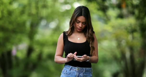 Όμορφη Ισπανόφωνη Γυναίκα Που Χρησιμοποιεί Συσκευή Smartphone Έξω — Αρχείο Βίντεο