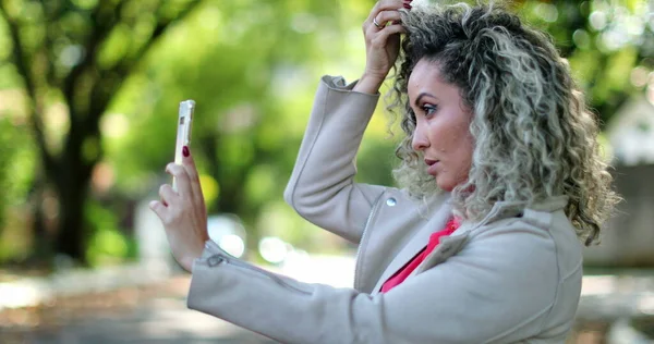 Mulher Ajustando Cabelo Rosto Frente Câmera Celular Fora — Fotografia de Stock