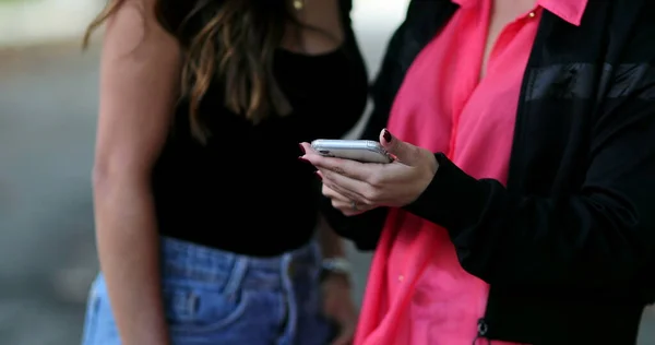 Две Женщины Смотрят Экран Мобильного Телефона Вместе Снаружи — стоковое фото