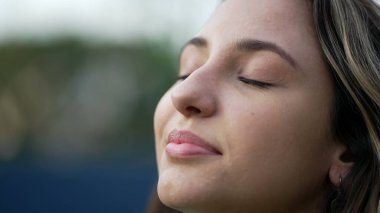 Genç İspanyol kadın meditasyonda gözlerini kapatıyor. Yirmili yaşlarda bir kız gözlerini açtığında gülümsüyor. Yakından bir kadın yüzü