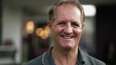 Açık havada gülümseyen mutlu olgun bir adamın portresi. 50 'li yaşlarda bir erkeğin yakın çekim yüzü.