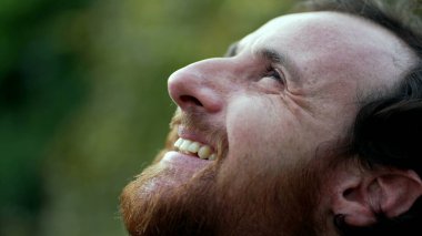 Minnettar adam meditasyonda gözlerini kapatıyor. UMUT ve FAITH ile gökyüzüne bakan kişi. Manevi bir insan dalgın dalgın gülümsüyor.