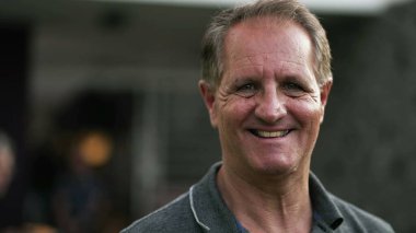 Açık havada gülümseyen mutlu olgun bir adamın portresi. 50 'li yaşlarda bir erkeğin yakın çekim yüzü.