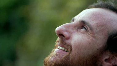 Minnettar adam meditasyonda gözlerini kapatıyor. UMUT ve FAITH ile gökyüzüne bakan kişi. Manevi bir insan dalgın dalgın gülümsüyor.