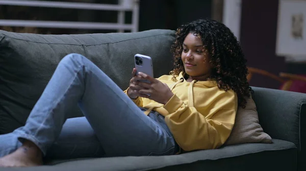 Een Jonge Zwarte Vrouw Zit Bank Naar Een Smartphone Kijken — Stockfoto