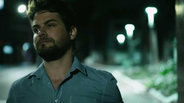 Şehir merkezinde geceleri yürüyen ciddi bir genç adam. Düşünceli düşünceli insan gece şehir kaldırımında yürür.