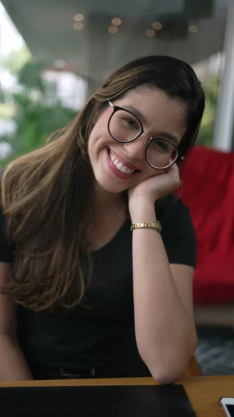 ある幸せな若い女性がカメラで微笑んだ 魅力的な20代の女の子着用眼鏡でコーヒーショップで垂直ビデオSs — ストック写真