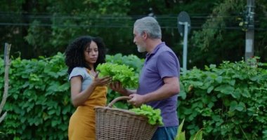 İki farklı toplum çiftçisi dışarıda organik marul kokusu alıyor. Zenci bir kadın ve orta yaşlı bir adam yemek yetiştirmekten bahsediyorlar.