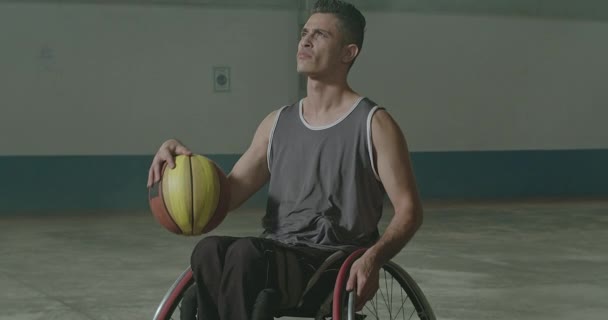 スポーツコート内のバスケットボールボールを保持車椅子にブラジルの麻痺障害者選手の肖像画 — ストック動画