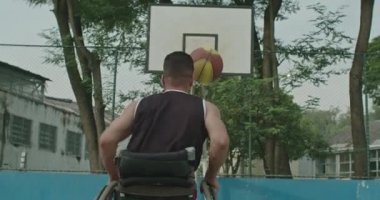 Basketbol antrenmanını kaçıran engelli bir sporcu. Deneme yanılma konsepti. Spor ve sakatlık. Tekerlekli sandalyedeki belden aşağısı felçli genç bir adam basketbol antrenmanını kaçırdı.