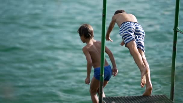 Çocuklar Sıcak Yaz Gününde Iskelede Göle Dalıyorlar Çocuklar Tatilin Tadını — Stok video