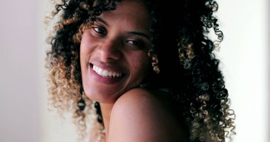 Mutlu Brezilyalı genç bayan gülüyor ve gülümsüyor. İspanyol siyahi kadın, yakın çekim yüzü.