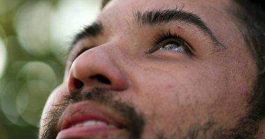 Minnettar İspanyol adam gökyüzüne bakıyor. Ruhani insan gülümsüyor