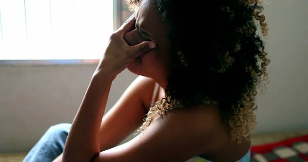 Tearful Brazilian woman crying, black latina girl in tears sitting in bed