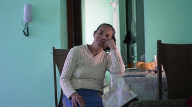 Evde tek başına oturan yaşlı bir kadın. Düşünceli, yalnız, yaşlı bir insan.