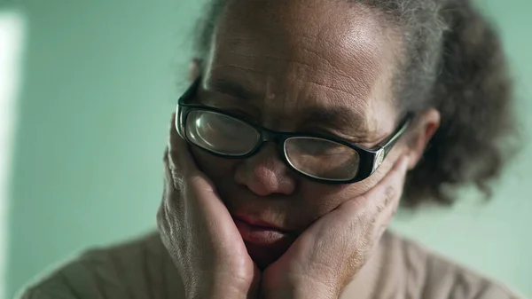 Pensive hispanic older woman closeup face with sad expression. Preoccupied South American senior lady in contemplation. Person in dilemma