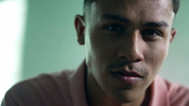 Latin asıllı genç bir adamın portresi. Kameraya bakarken yüzünde ciddi bir ifade var. Genç bir Brezilyalı Güney Amerikalı.