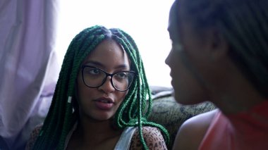 Konuşan iki genç siyah kız samimi bayan arkadaşlar konuşuyor.