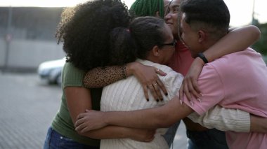 Siyah bir aile kucaklaşması. Güney Amerikalı bir grup Latin Amerikalı açık havada birbirlerine sarılıyorlar. Kucaklaşan mutlu arkadaşların portresi. Arkadaşlık kavramı 
