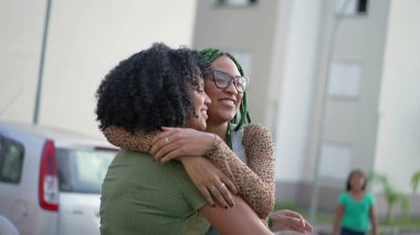 İki mutlu Brezilyalı zenci kadın birlikte gülüp gülüyor. Eğlenceli yetişkin kızlar dışarıda durmayı sever. Arkadaşlık kavramı