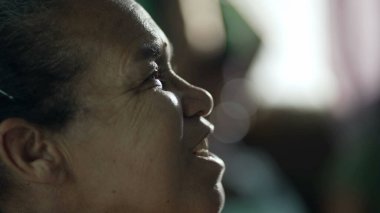 Meditasyon yapan son sınıf öğrencisi kadın tefekkür yaparken gözlerini kapatıyor. Meditasyondaki ruhani yaşlı kadın. Profil, Güney Amerikalı bir kadının gözlerini açtığını gösteriyor.