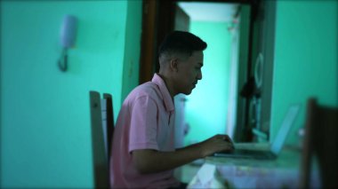 Laptop bilgisayarının önünde İspanyol bir adam. Latin kişi evdeki oturma odasında internete göz atıyor