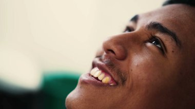 Genç bir İspanyol, umutla ve inançla gökyüzüne bakıp gülümsüyor. Ruhani Brezilyalı adam kendini çok iyi hissediyor.