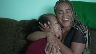 Latin Latin kökenli büyük anne ve yetişkin kız birlikte sevgi ve kucaklaşma. Brezilyalılar birlikte sevgi gösteriyorlar