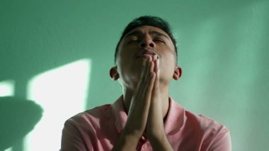 Dini bütün, genç bir adam Tanrı 'ya yüce bir duayla dua ediyor. Güney Amerikalı Brezilyalı dua ederken gökyüzüne umutla ve inançla bakıyor.