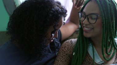 Kız kardeşler birbirlerine sarılıyorlar. İki yetişkin siyahi arkadaş sarılıyorlar.