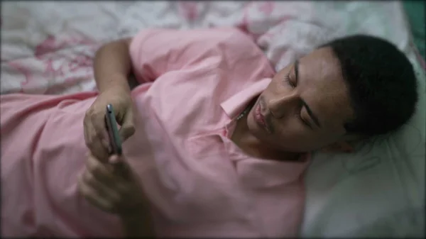 Jeden Hiszpan Leży Łóżku Pomocą Smartfona Południowoamerykańska Młoda Osoba Patrząca — Zdjęcie stockowe